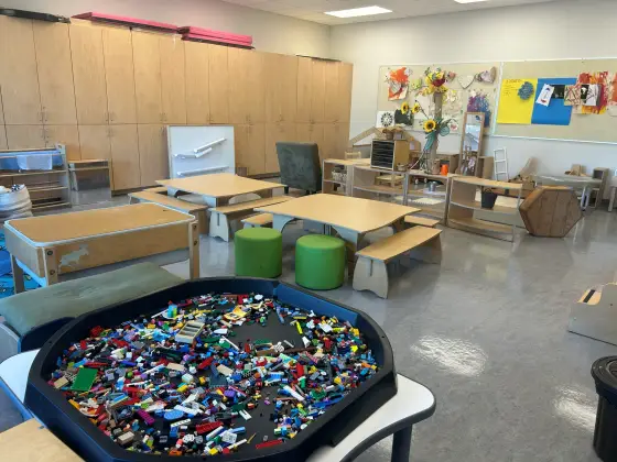 A large tray of building bricks in the Butterfly Room, with tables and stools behind it